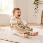 Toddler turning the steering wheel of the wooden busy board on their lap