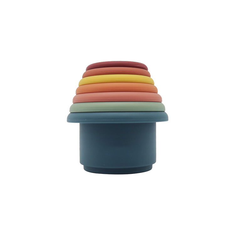 Silicone stacking cups nested into a single tower in a warm palette of teal, terracotta, sage and cream
