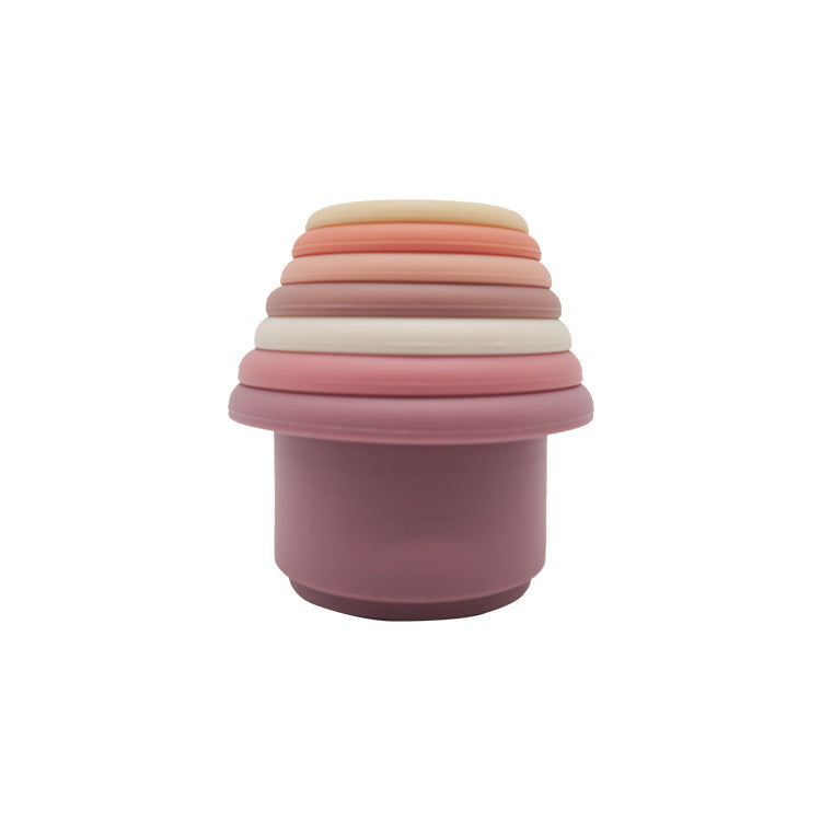 Silicone stacking cups nested into a single tower in a pink palette of mauve, blush and cream