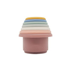 Silicone stacking cups nested into a single tower in a cool palette of dusty pink, grey, blue and cream