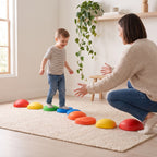 Parent encouraging their child along a stepping stone course across the floor