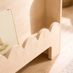 Macro of the scalloped front edge of the birch toddler bookshelf tier