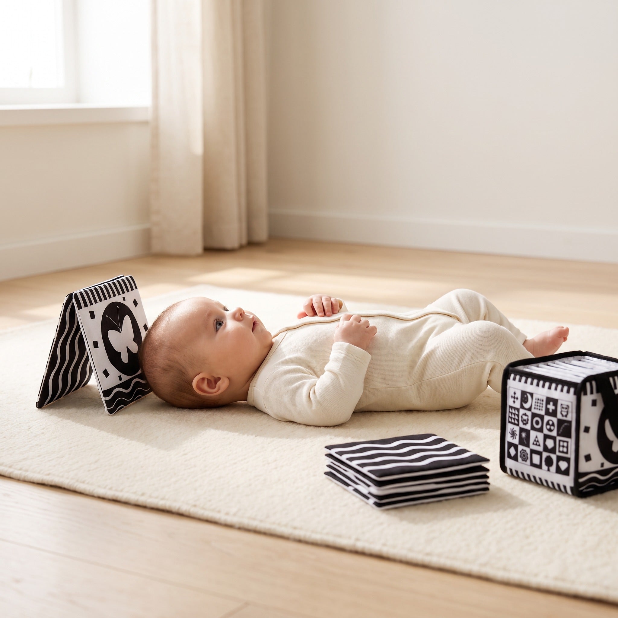 Three-month-old baby lying on their back gazing at a black and white high-contrast card