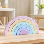 Pastel macaron rainbow wooden stacker assembled on a wooden table in a bright nursery