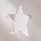 Macro of the star cut-out in the white painted toddler tower panel, showing the rounded child-safe edge