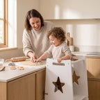 Parent and toddler baking together, the child raised to counter height in the helper tower
