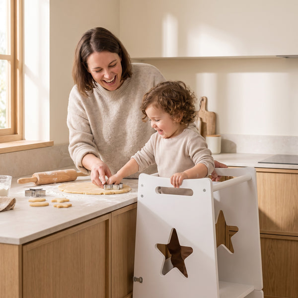 Parent and toddler baking together, the child raised to counter height in the helper tower