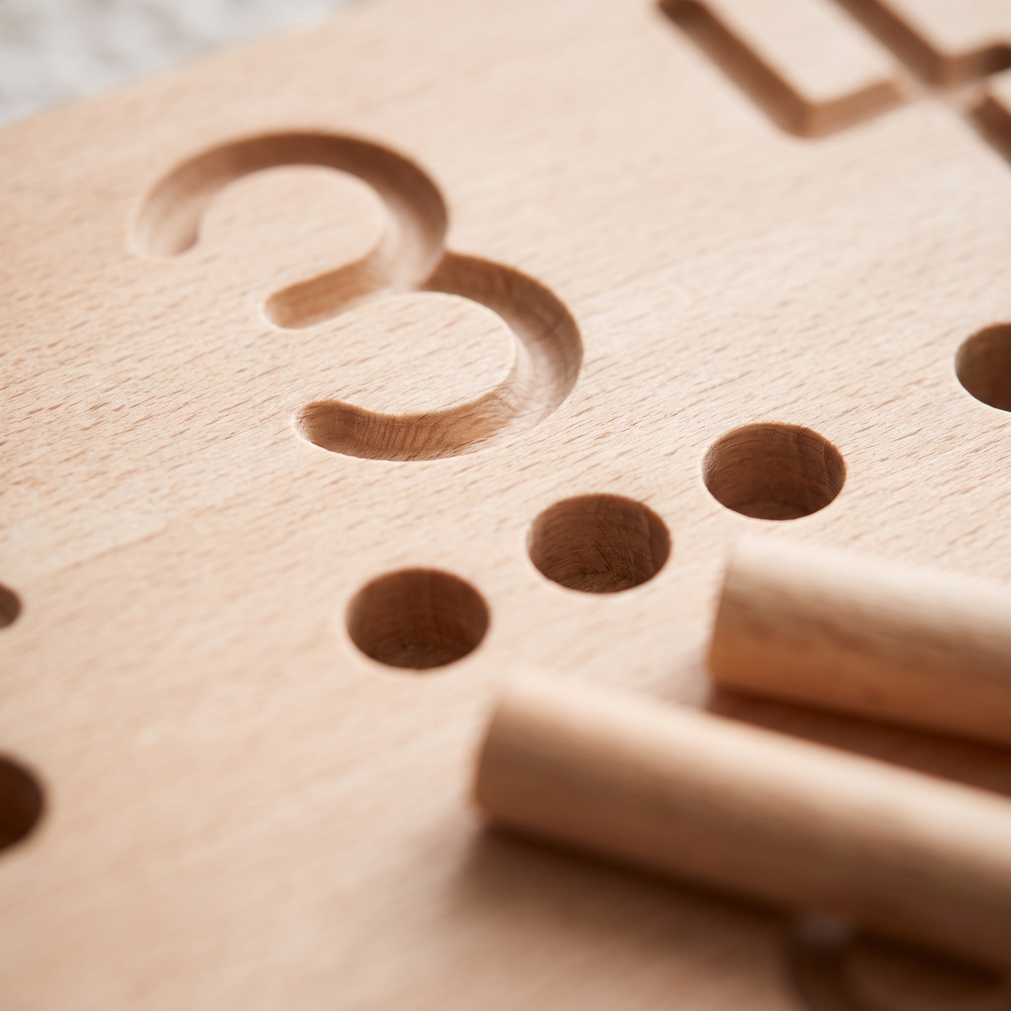 Macro of the engraved numeral 3 groove and counting holes on the birch tracing board
