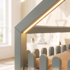 Close-up of the warm LED strip glowing along the grey house roof frame of the Montessori floor bed