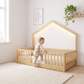 Toddler climbing into the twin size natural wood Montessori floor bed with the LED roof lighting on