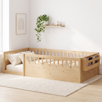 Twin natural Montessori floor bed with high rails and side storage shelf, made up with cream bedding in a bright Scandinavian nursery