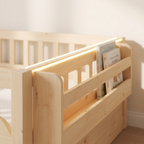 Close-up of the side storage shelf holding picture books, with the LED strip glowing along the rail above