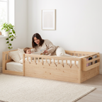 Parent lying inside the twin natural Montessori floor bed reading a picture book to their toddler