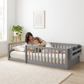 Parent lying inside the twin grey Montessori floor bed reading a picture book to their toddler