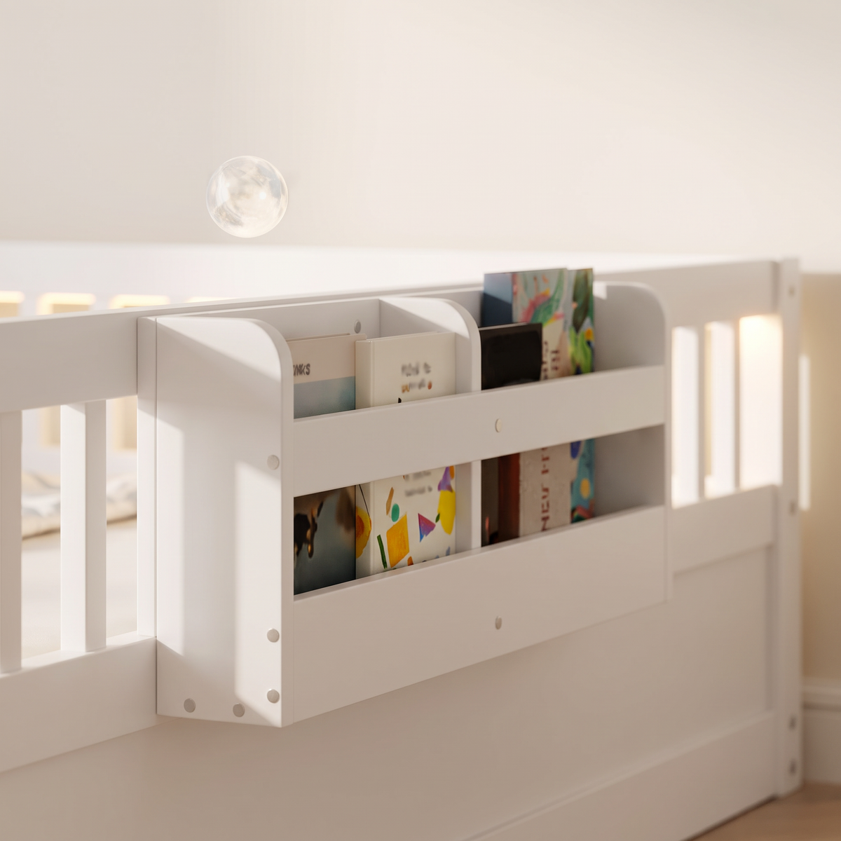 Close-up of the side storage shelf on the white Montessori floor bed holding picture books