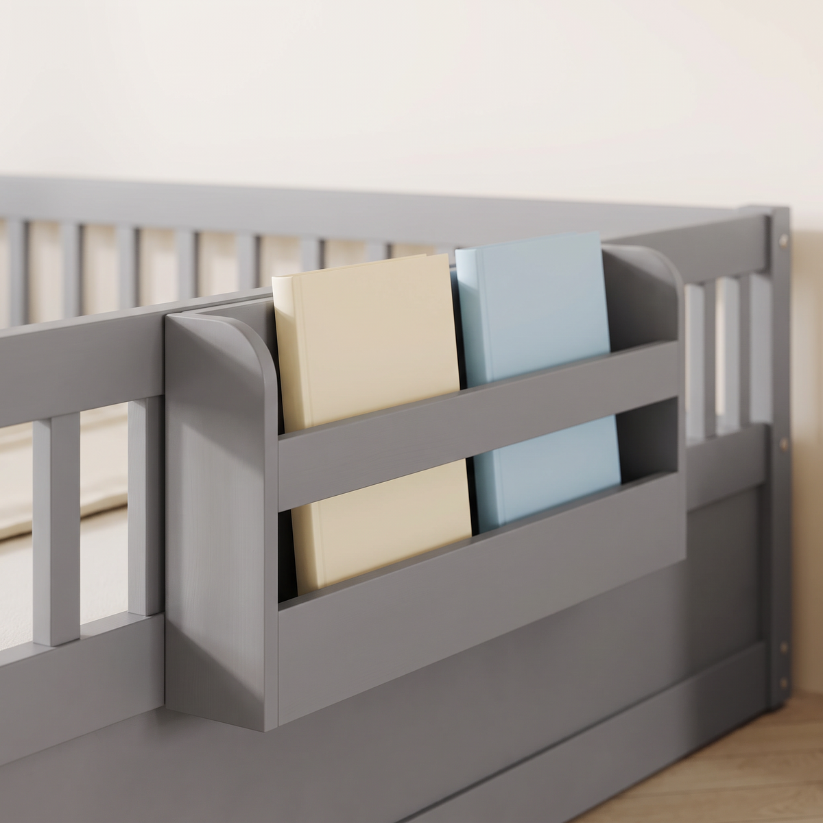 Close-up of the side storage shelf on the full size grey Montessori floor bed holding picture books