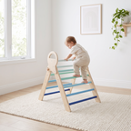 Toddler climbing the rungs of the blue wooden Pikler triangle